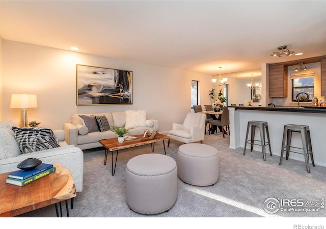 living room featuring a chandelier and carpet