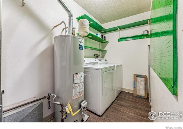 laundry area with water heater, dark wood-type flooring, a textured ceiling, and washing machine and clothes dryer