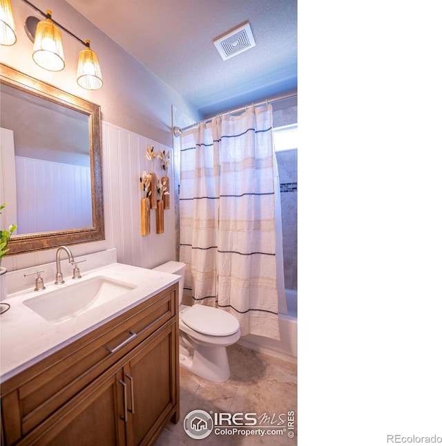 full bathroom with vanity, shower / bath combo with shower curtain, a textured ceiling, and toilet