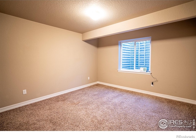 carpeted empty room with a textured ceiling