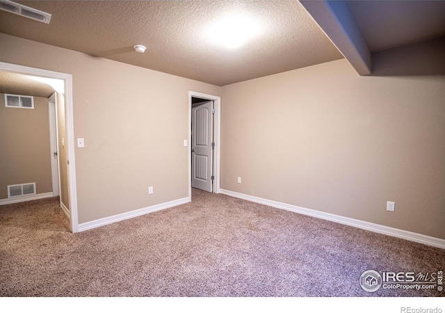 carpeted spare room with a textured ceiling