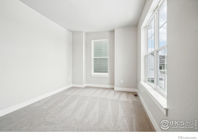 spare room with light colored carpet and plenty of natural light