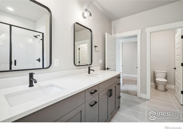 bathroom with toilet, vanity, tile patterned flooring, and a tile shower