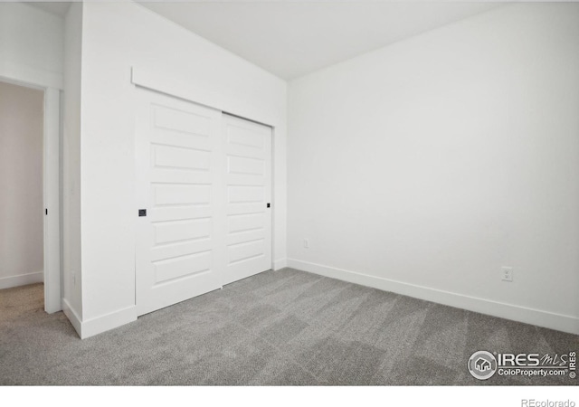 unfurnished bedroom with a closet and light carpet