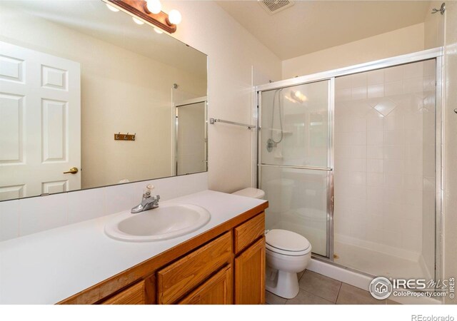 818 S Terry St Unit 85, Longmont, CO 80501 - bathroom featuring toilet, a stall shower, vanity, and tile patterned flooring