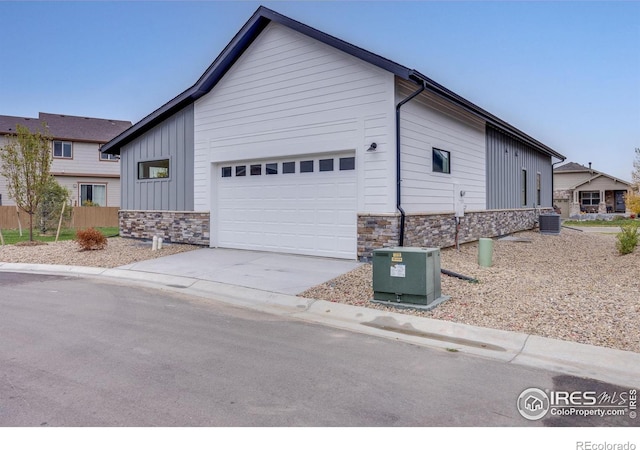 view of front of home with a garage and central AC