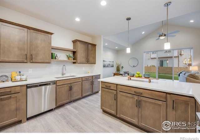 kitchen featuring lofted ceiling, dishwasher, decorative backsplash, sink, and light wood-type flooring