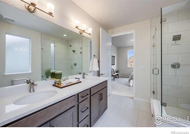 bathroom with tile patterned flooring, vanity, and a shower with door