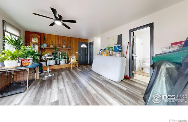 kitchen featuring hardwood / wood-style flooring, ceiling fan, and wooden walls