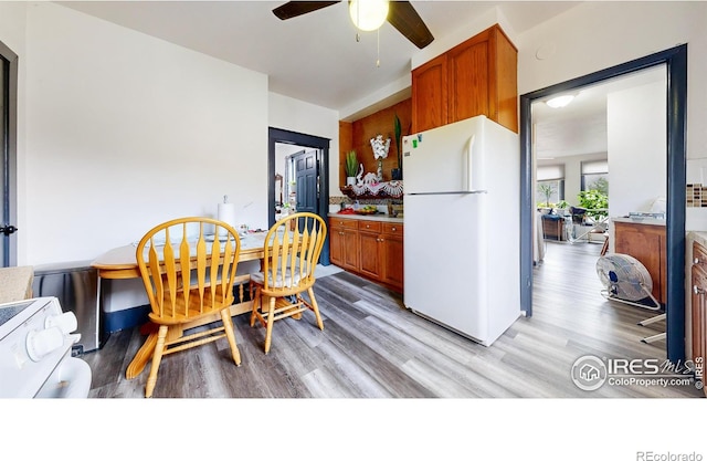 kitchen featuring ceiling fan, white appliances, and light wood-type flooring