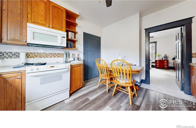 kitchen with ceiling fan, backsplash, white appliances, and light hardwood / wood-style flooring