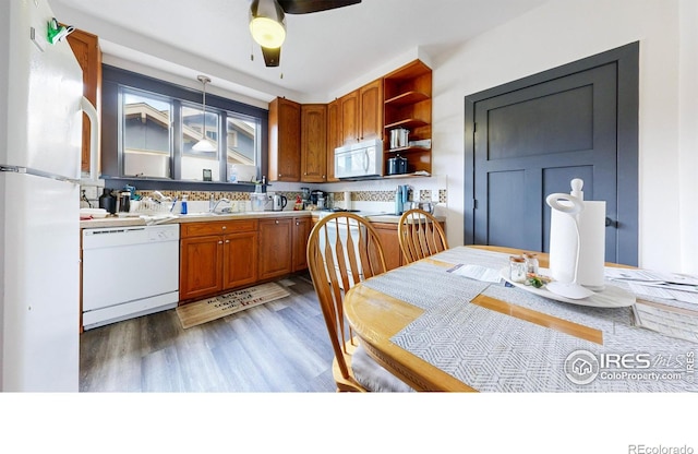 kitchen featuring pendant lighting, sink, ceiling fan, light hardwood / wood-style floors, and white appliances