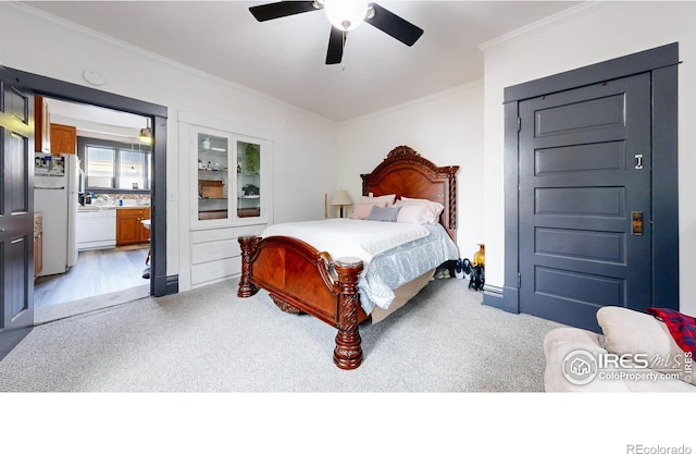 bedroom with white refrigerator, crown molding, ensuite bathroom, and ceiling fan