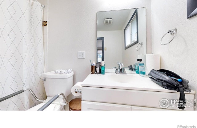 bathroom featuring vanity, toilet, and a shower with shower curtain