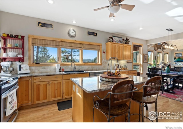 kitchen with stainless steel electric range, light hardwood / wood-style flooring, sink, and light stone counters