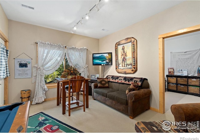 carpeted living room with rail lighting