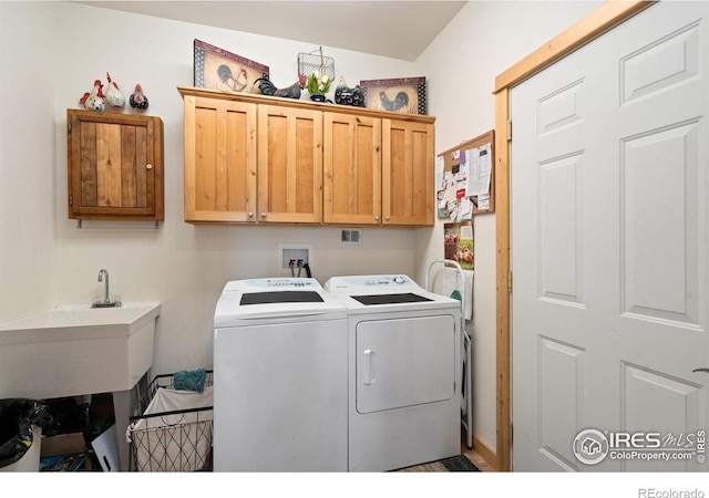 laundry room featuring cabinets, washer and clothes dryer, and sink