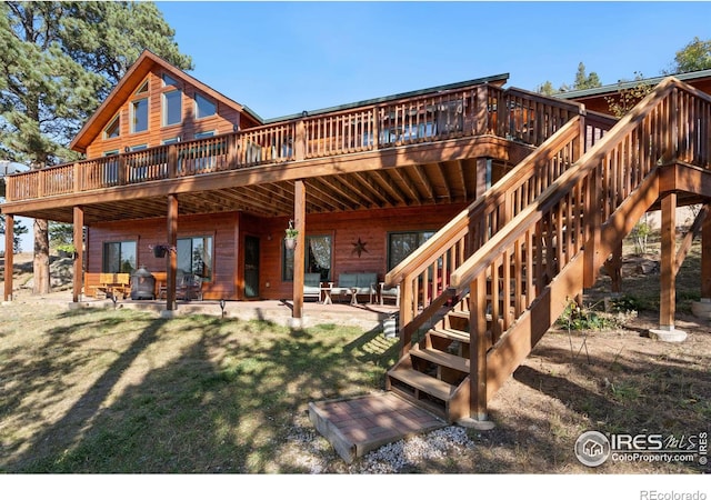 back of property with a patio, a lawn, and a deck