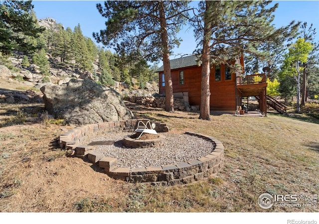 view of yard featuring a deck and an outdoor fire pit