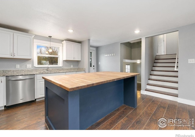 kitchen with butcher block counters, white cabinetry, a kitchen island, and stainless steel dishwasher