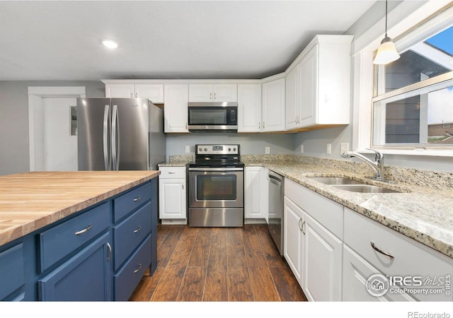 kitchen featuring stainless steel appliances, a sink, white cabinets, and blue cabinets