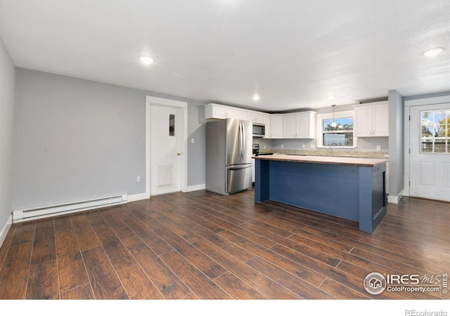 kitchen with light countertops, appliances with stainless steel finishes, a baseboard heating unit, white cabinets, and a kitchen island