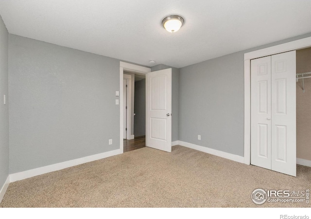 unfurnished bedroom featuring carpet floors, a closet, and baseboards