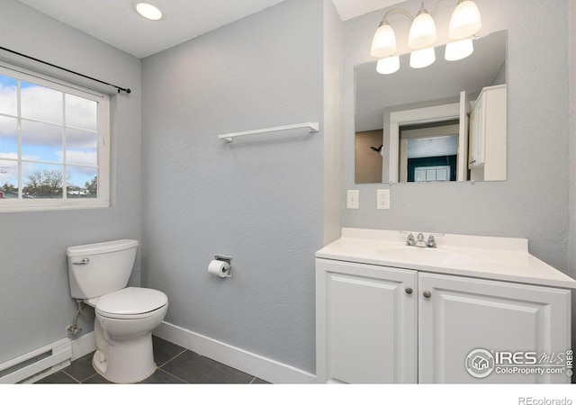 bathroom featuring baseboards, toilet, tile patterned floors, vanity, and a baseboard heating unit