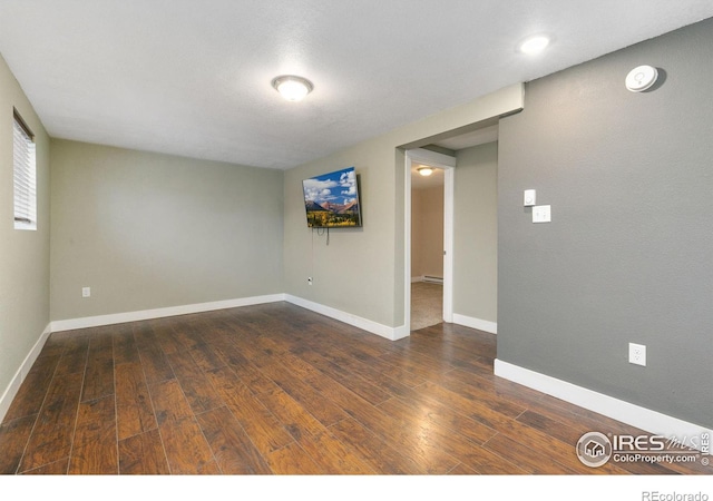 empty room featuring dark wood-style floors and baseboards