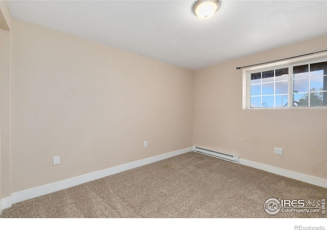 empty room with a baseboard heating unit, carpet flooring, and baseboards