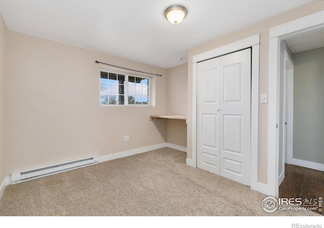 unfurnished bedroom featuring carpet, a baseboard radiator, baseboards, and a closet