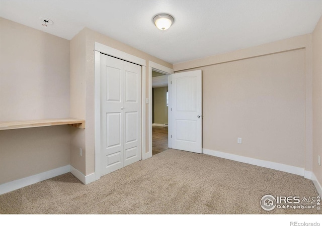 unfurnished bedroom with carpet floors and baseboards