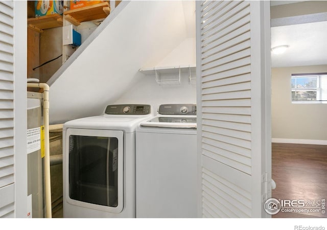 laundry area featuring laundry area, dark wood finished floors, washer and clothes dryer, and baseboards