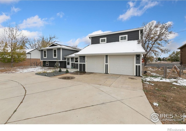 view of front facade featuring driveway and fence