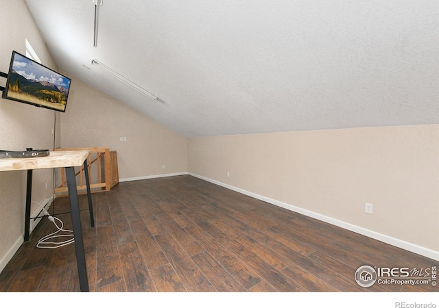 bonus room with lofted ceiling, dark wood-style flooring, a textured ceiling, and baseboards