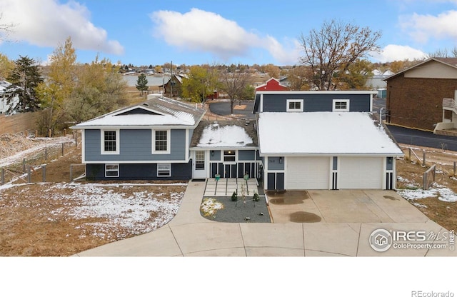 view of front of house with concrete driveway, an attached garage, and fence