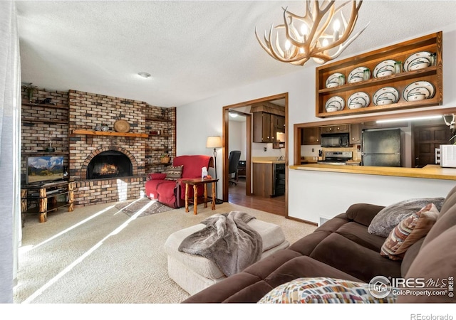 living room featuring a brick fireplace, light colored carpet, a textured ceiling, and an inviting chandelier