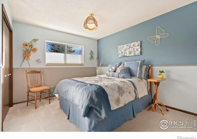 bedroom featuring a textured ceiling, light carpet, and a closet