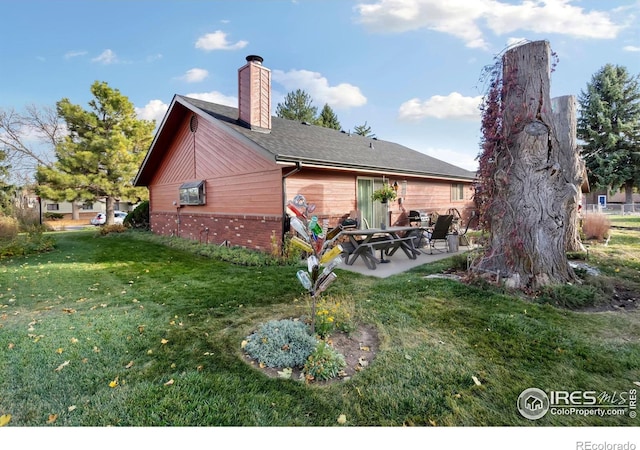 rear view of property with a patio and a yard