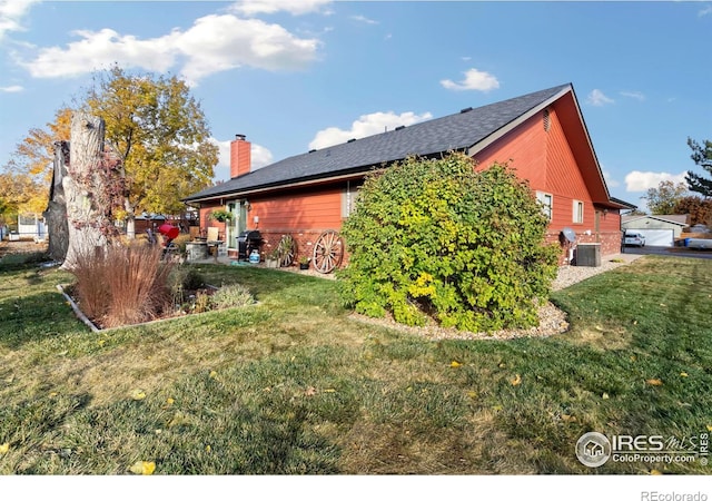 view of side of home with central air condition unit and a lawn