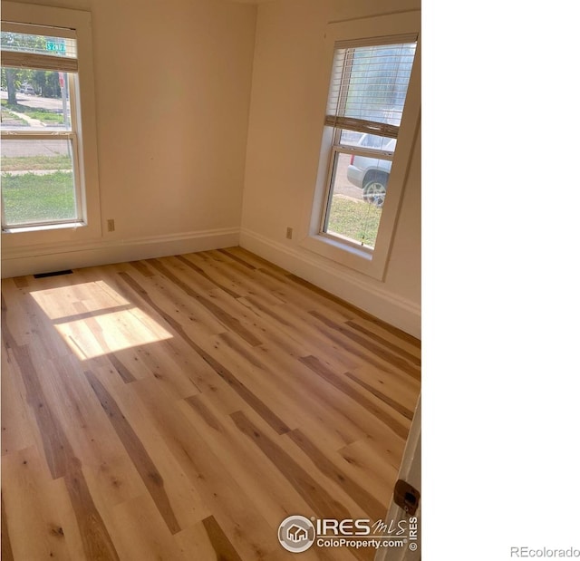 empty room with plenty of natural light and light wood-type flooring