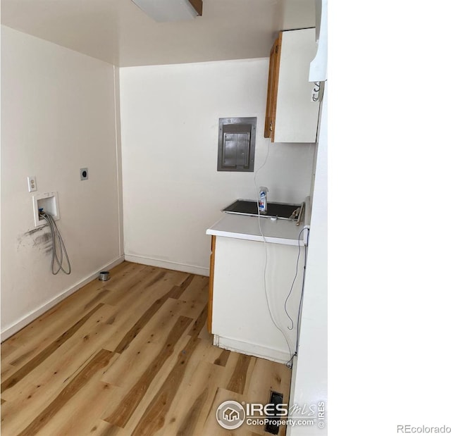 laundry area with electric dryer hookup, electric panel, washer hookup, and light wood-type flooring