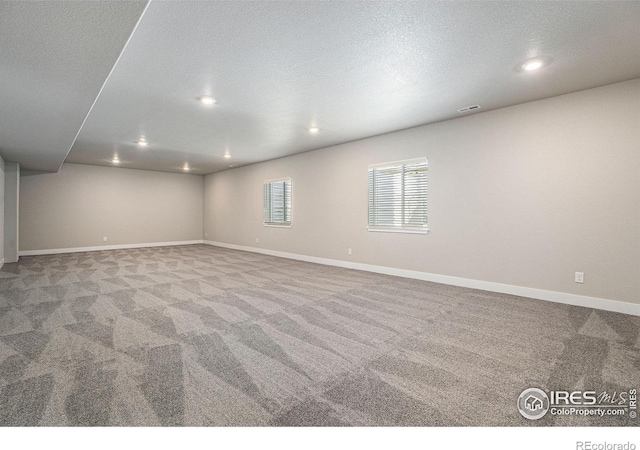 empty room featuring light colored carpet and a textured ceiling