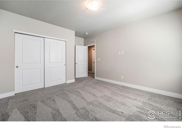 unfurnished bedroom featuring carpet flooring and a closet