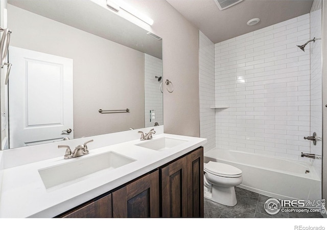 full bathroom with tile patterned flooring, vanity, toilet, and tiled shower / bath