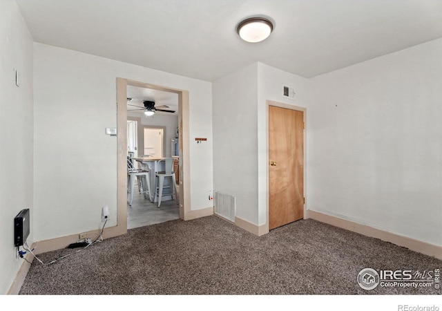 empty room featuring carpet flooring and ceiling fan