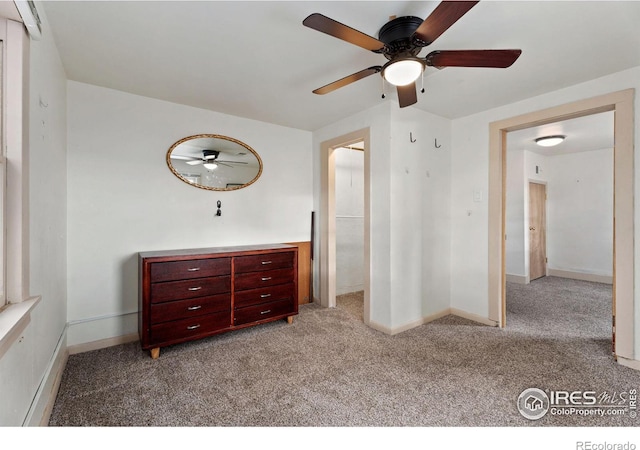 unfurnished bedroom featuring an AC wall unit, light colored carpet, and ceiling fan