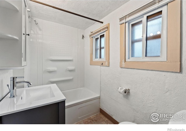 bathroom with vanity, a textured ceiling, and  shower combination