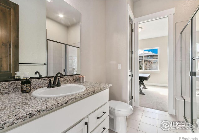 bathroom with toilet, vanity, tile patterned floors, and a shower with door