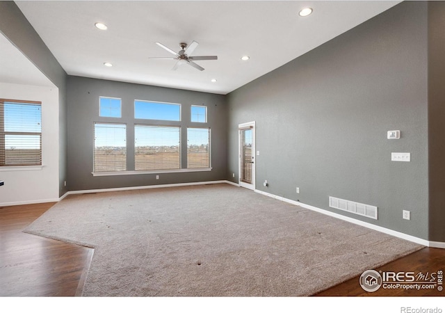 unfurnished room with a wealth of natural light, hardwood / wood-style flooring, and ceiling fan